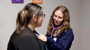 A medical provider using a stethoscope on a patient.