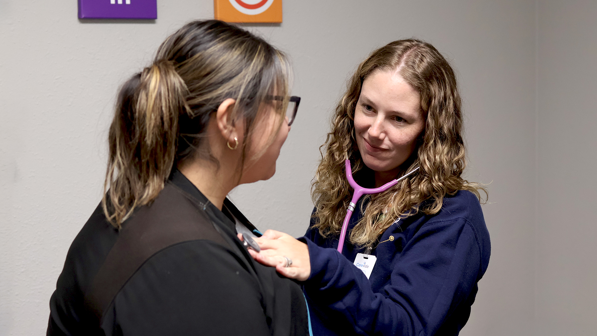 A medical provider using a stethoscope on a patient.