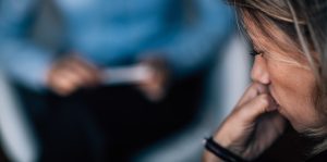 A woman contemplates during a behavioral health session